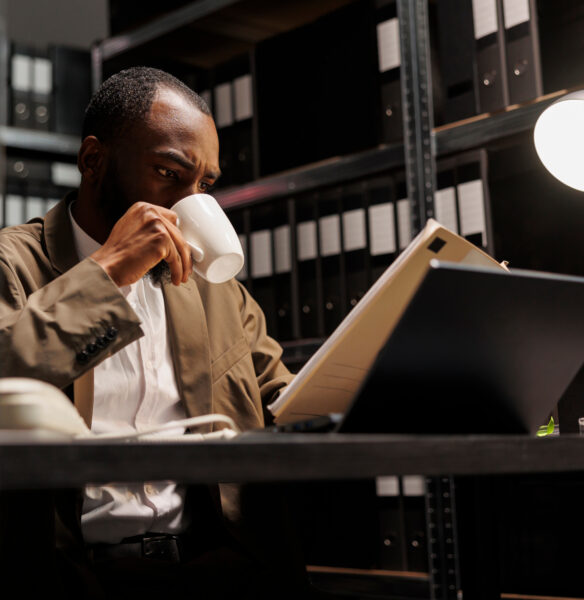 Un homme buvant un café et lisant des dossiers